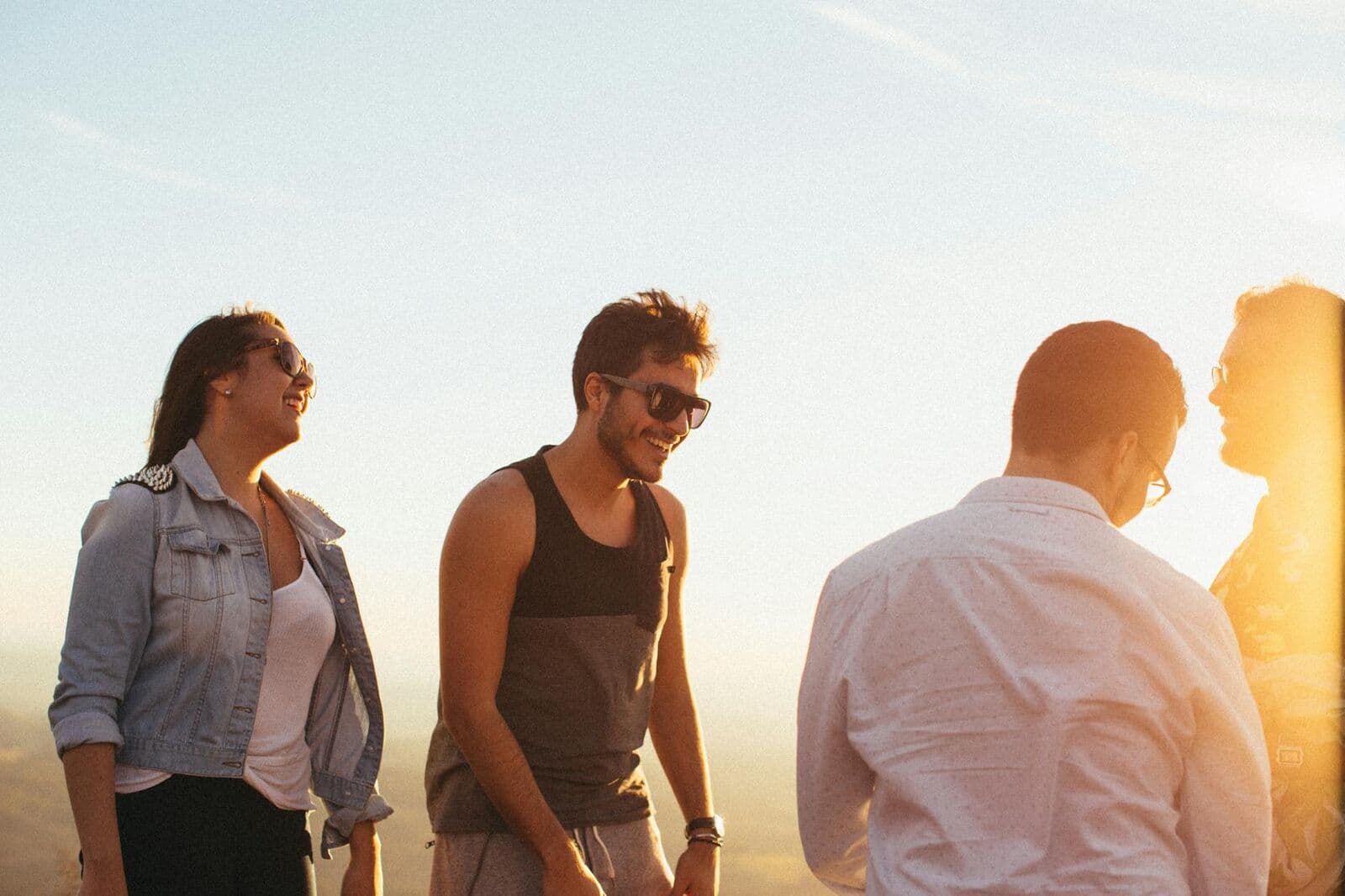 Friends laughing together outdoors at golden hour